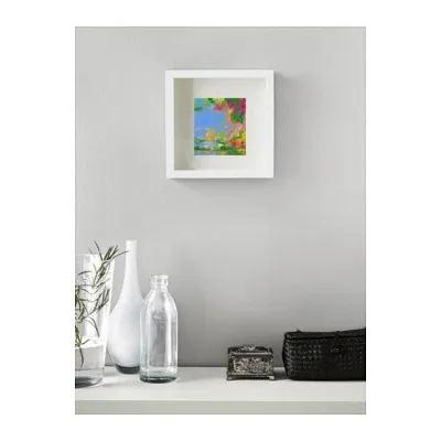 A small framed abstract on a white wall above a console with glass bottles