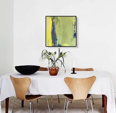 A yellow-green abstract above a dining table with white chairs